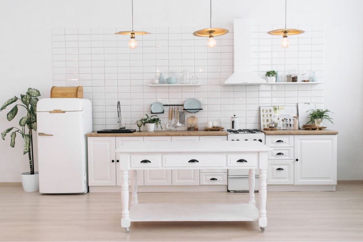 Light kitchen with white cabinetry and a central worktable